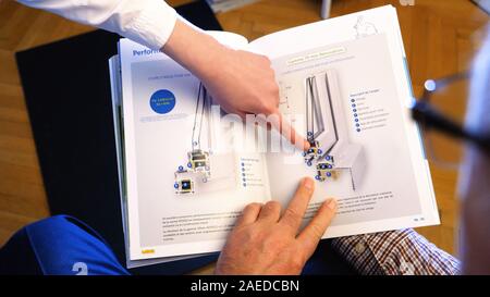 Paris, France - Circa 2019 : l'écoute et la jeune femme expliquant l'efficacité énergétique et l'isolation acoustique des fenêtres double vitrage dans catalogue marketing Banque D'Images