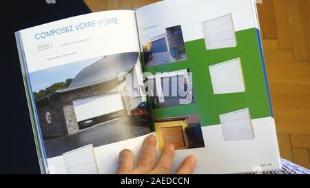 Paris, France - Sep 13, 2019 : part à la recherche à la brochure commerciale catalogue divers type de portes de garage pour la nouvelle maison Banque D'Images