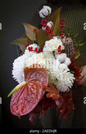 Mains femme est titulaire d'un Noël ou Nouvel An composition bouquet sur un fond sombre, selective focus Banque D'Images