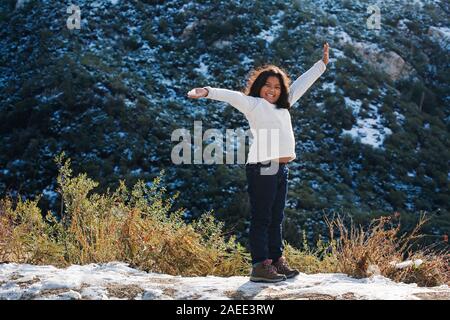 9 ans, fille, et excité au sujet de la randonnée dans les montagnes San Gabriel pendant la saison d'hiver. Banque D'Images