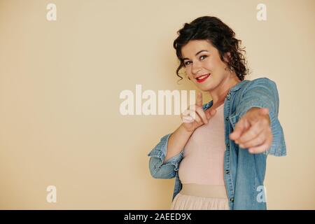 Cheerful young attractive Caucasian woman pointing at camera avec deux doigts Banque D'Images