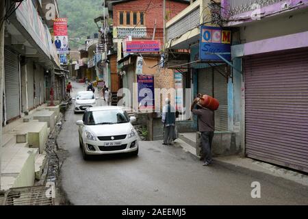 Man bouteille de GPL dans rue étroite, Banjar ville, Tirthan Valley, Kullu, Himachal Pradesh, Inde, Asie Banque D'Images