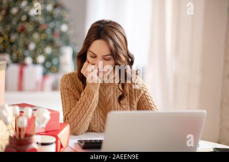 Jolie jeune femme avec de longs cheveux de penser à son travail Banque D'Images