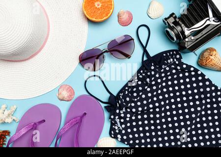 Un ensemble de vêtements et accessoires pour se détendre sur un fond bleu. Carte de vœux. Le concept de vacances, l'été, la mer, les voyages. Banque D'Images