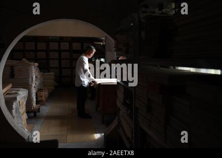 (191209) -- JINGXIAN, le 9 décembre 2019 (Xinhua) -- Cao Jianqin vérifie la qualité de papier à l'Zijinlou Xuan Xuan usine à papier dans le comté de Jingxian, Ville de Xuancheng Anhui Province de Chine orientale, le 22 octobre 2019. Papier Xuan, chinois traditionnel papier fabriqué dans le comté de Jingxian de Hefei City, a une histoire de plus de 1 000 ans. Passer par plus de 100 procédures, la fabrication du papier coûte au moins un an pour mettre le matériel dans le produit final. Connu pour son artisanat de qualité fine, distinguée et préserver le temps, le papier est aimé par les artistes chinois et de calligraphie et est la calle Banque D'Images
