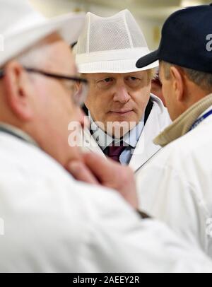 Premier ministre Boris Johnson à l'écoute au cours d'une visite au marché aux poissons de Grimsby, tandis que sur la campagne électorale générale trail. Banque D'Images