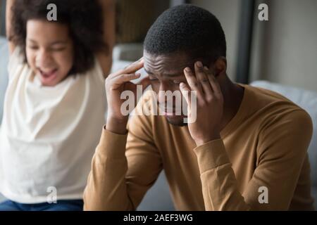 Fatigué papa noir souffrent de maux de tête et fille désobéissante Banque D'Images