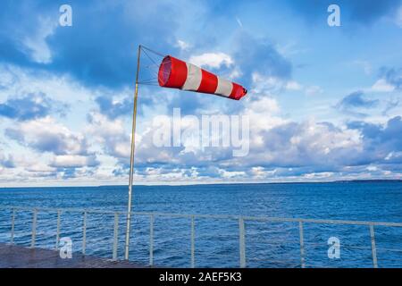 Cône de moulin à vent sur un quai dans un port maritime à un coup de vent Banque D'Images