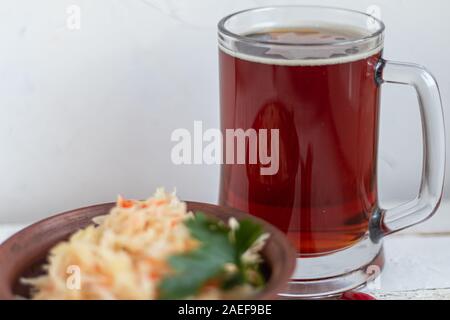 Un grand verre de bière froide. Chou mariné, fermentés dans un bol. Banque D'Images