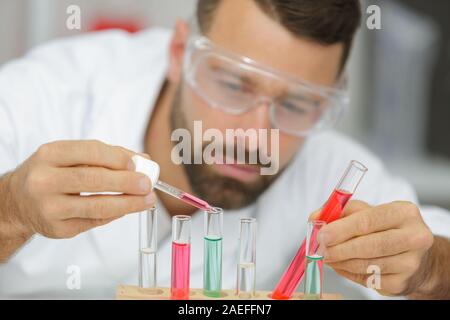 Dans le liquide dégoulinant scientifique test tube Banque D'Images