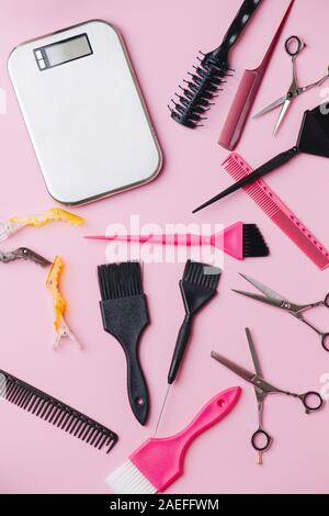Outils de coiffure : échelles, des pinceaux, des ciseaux, des peignes et des clips sur pink Banque D'Images