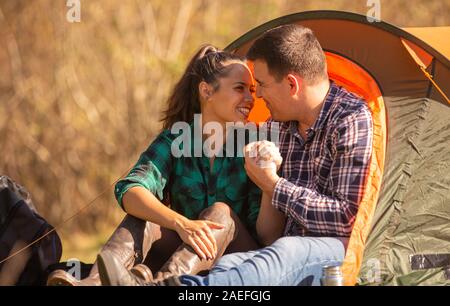 Couple d'amoureux souriant en face de la tente. Atmosphère romantique Banque D'Images