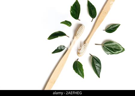 Deux brosses à dents en bois et bambou eco friendly feuille verte sur fond blanc. Les soins dentaires et concept zéro déchet. Mise à plat, vue du dessus, copy space Banque D'Images