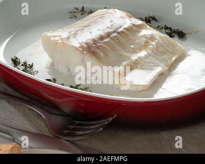 Filet de poisson de la morue, fraîchement préparé au four avec le thym dans un plat en porcelaine à cuire, Close up, side view Banque D'Images