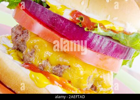 Hamburger fait maison avec du boeuf haché et fromage fondu. Les fixations sont classiques sur il y compris les tranches de légumes et de condiments. Banque D'Images