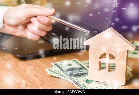 Maison en bois miniature avec la neige et d'affaires. Marché immobilier en hiver. Offres et promotions favorables. Vente de logements. Noël. Nouvelle Année. Banque D'Images