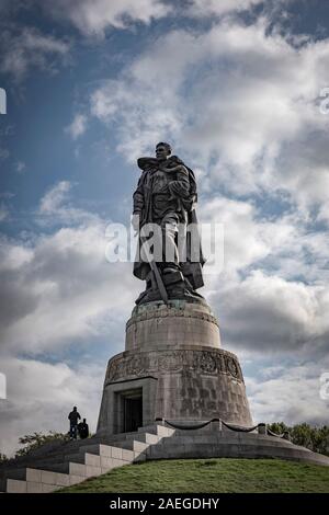 Une sculpture de sergent de gardiens Nikolai Masalov debout sur une croix gammée brisée et tenant un enfant allemand dans le mémorial de guerre soviétique, parc de Treptow Banque D'Images