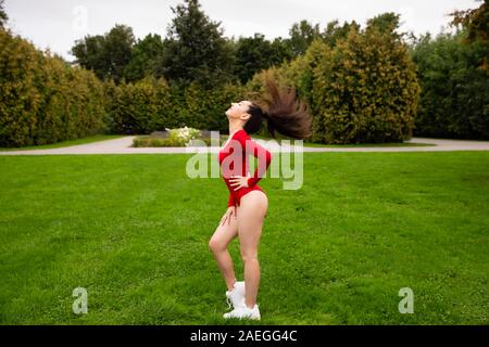 Beautiful Girl doing stretching sportif dans le parc Banque D'Images