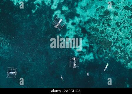 Vue aérienne de pêcheur traditionnel indonésien bateaux dans l'eau turquoise on tropical beach. Tir de drone au dessus Banque D'Images