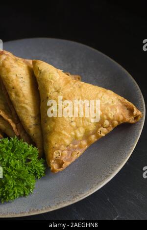 Un mélange épicé Samosas de légumes ou de viande enveloppé dans une pâtisserie frite parcelle triangulaire un snack populaire au Moyen-Orient et en Asie du Sud Banque D'Images