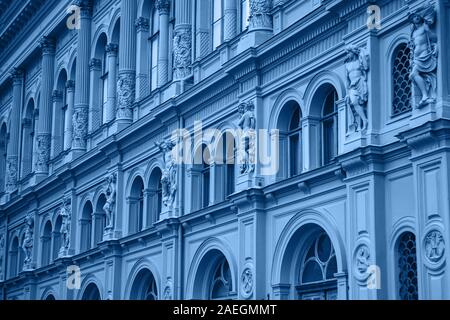 Un vieux bâtiment avec de nombreuses fenêtres d'affilée dans un quartier branché de style bleu classique. Banque D'Images