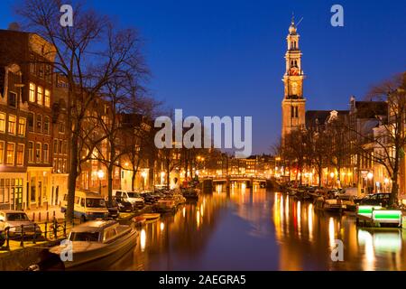 L'église Westerkerk (ouest) le long du canal Prinsengracht à Amsterdam dans la nuit. Banque D'Images