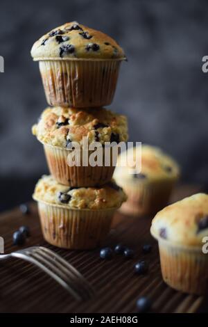 Haut Crumble muffins aux bleuets en tas sur oak board sur fond sombre avec un éclairage naturel copy space Banque D'Images