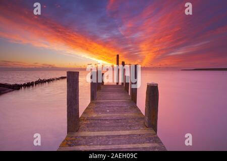 Lever de soleil spectaculaire sur une couleurs jetée sur la mer sur l'île de Texel aux Pays-Bas. Banque D'Images
