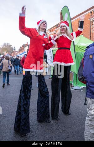 Échassiers habillés en costumes santa au marché de Noël 2019 de Farnham dans le centre-ville, Surrey, UK Banque D'Images