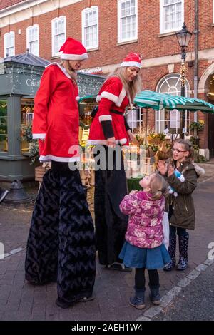 Échassiers habillés en costumes santa au marché de Noël 2019 de Farnham dans le centre-ville, Surrey, UK Banque D'Images