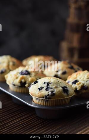 Haut crumble délicieux muffins aux bleuets en allant au four sur fond noir avec lumière naturelle vue latérale copy space Banque D'Images