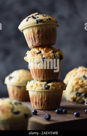 Des petits muffins crumble myrtilles sauvages avec disposés en pile instable sur fond sombre copie espace. Clé faible vie encore avec l'éclairage naturel c Banque D'Images