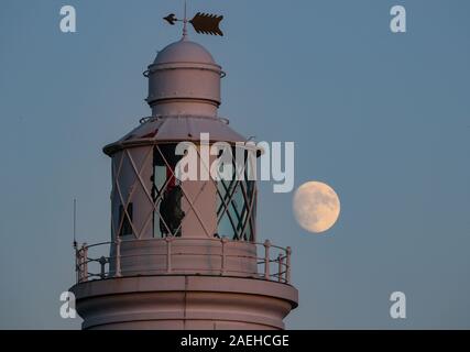 Keyhaven, Hampshire, Royaume-Uni. 9 décembre 2019, UK Weather : La Lune gibbeuse invoque le soir clair au-dessus de Hurst Point Lighthouse dans Keyhaven, Hampshire avant la pleine lune froide qui s'affiche ce jeudi 12 décembre à 5.12am GMT. Stuart Martin Crédit/Alamy Live News Banque D'Images