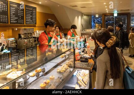 Les clients d'attente dans magasin Starbucks, Ginza, Tokyo, Japon Banque D'Images