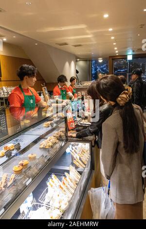 Les clients d'attente dans magasin Starbucks, Ginza, Tokyo, Japon Banque D'Images