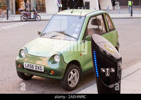 Un G-Wiz voiture électrique dans les rues de Londres, au Royaume-Uni. Ces véhicules sans émissions aident à lutter contre le changement climatique avec une station de recharge pour véhicule électrique Banque D'Images