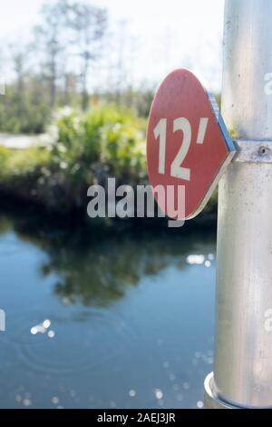 Un marqueur sur un pôle à 12 pieds montre les prévisions du niveau le niveau d'eau sera à dans l'année 2100 sur la promenade à l'Oasis Visitor Center de Big Cypress National Preserve à Ochopee, Florida, USA Banque D'Images