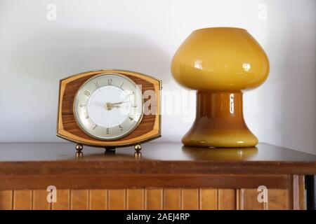 Décoration du milieu du siècle. L'horloge rétro ou rétro se concentre sur un fond de tableau latéral avec une lampe rétro à champignons en verre soufflé Banque D'Images