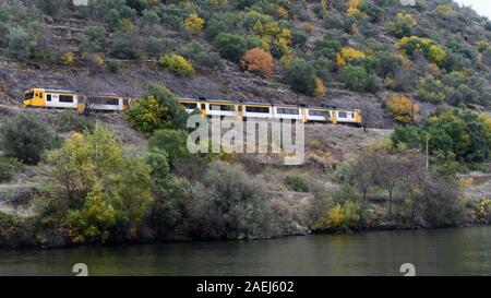 Train touristique se déplaçant le long de la rivière Douro, montagne, vallée du Douro, Portugal Banque D'Images