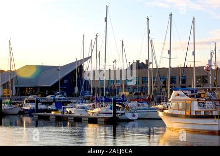 La marina du port d'Arbroath, rempli de yachts et bateaux de plaisance, éclairé par la chaude lumière directionnelle d'un soleil bas à la fin de la journée. Banque D'Images