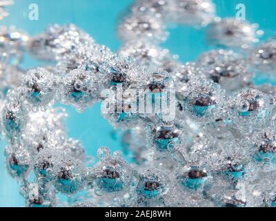 perles d'argent dans le verre à vin avec de l'eau, des bulles, macro, photo, fond pour le design. Banque D'Images