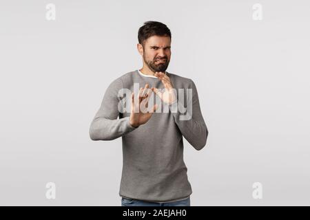 Eeew le prendre loin de moi. Dégoûté et déçu barbu pas en arrière et se défendre lui-même soulevé les mains, s'abstenir de dégoûtant produit stinky Banque D'Images