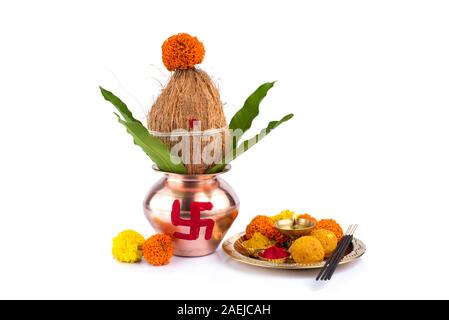 Kalash en cuivre avec des feuilles de coco et de mangue et pooja thali avec diya, kumkum et des bonbons avec décor floral sur fond blanc. Essentiel dans hind Banque D'Images