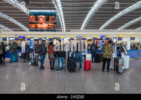 Les gens utilisent le libre-service de British Airways vérifier dans les machines à Heathrow Airport Terminal 5, London, UK Banque D'Images