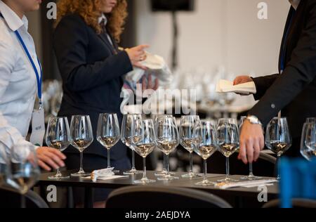 Jeu de serveuse les tables avec crystal gobles pour un atelier de dégustation de vin. Service de restauration et le personnel de salle à manger au travail. Banque D'Images