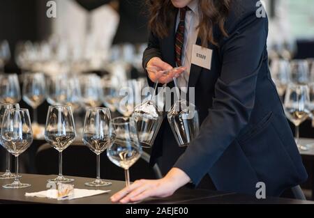 Jeu de serveuse les tables avec crystal gobles pour un atelier de dégustation de vin. Service de restauration et le personnel de salle à manger au travail. Banque D'Images