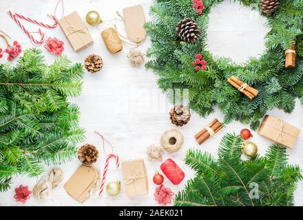 Vue de dessus de la couronne de Noël, branches de pin, présente sur la table en bois, eco tags et boîtes de papier brun, selective focus Banque D'Images