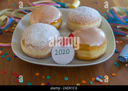 Quatre beignets sur une plaque blanche en particulier pour le Nouvel An Banque D'Images