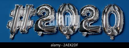 L'inscription de l'aluminium brillant gonflable ballon hashtag lettres 2020 sur fond bleu Banque D'Images