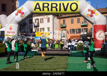 Runner de franchir la ligne d'arrivée du 10e Marathon de Barbaresco et Blanc Truffe dans le centre historique d'Alba, province de Cuneo, Piémont, Italie Banque D'Images